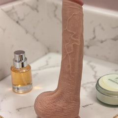 Dildo ultra realista Real King Magic Flesh con ventosa y testículos, textura suave y detallada, marca Glow & Vibe.