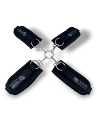 Glow&Vibe Bondage Lure negro, sistema de esposas de 4 puntos con velcro y conector central metálico para manos y pies.