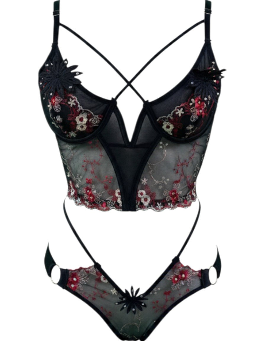Conjunto de lencería Glow&Vibe Crimson Obsession con bustier de encaje negro, bordados florales rojos y tiras tipo harness.