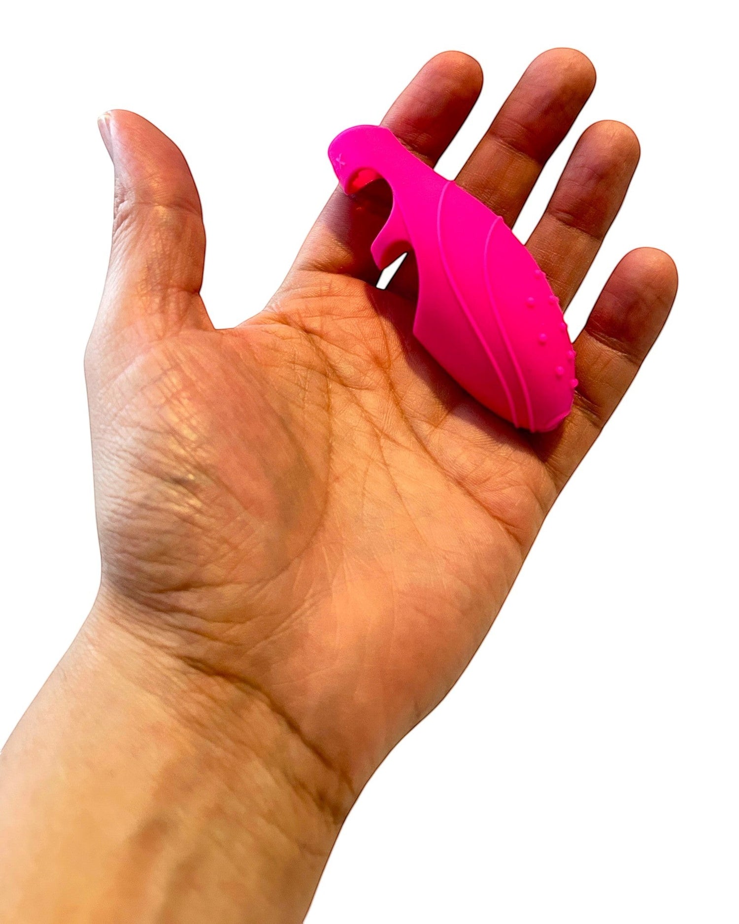 Dedal vibrador fucsia de silicón suave Silk Finger de Glow&Vibe sostenido en la palma de una mano
