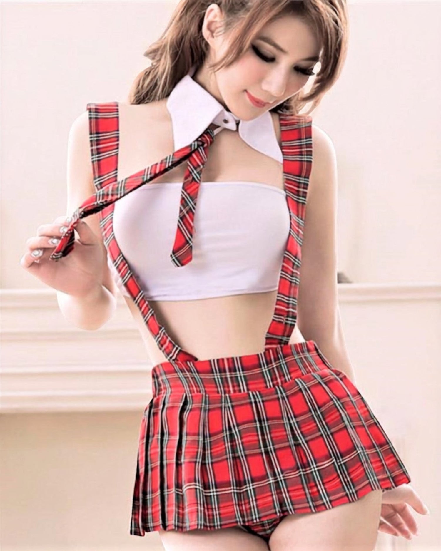 Disfraz Rebel Student de Glow&Vibe con falda escocesa roja, tirantes y top blanco estilo colegiala atrevida