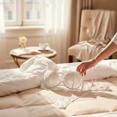 Set de lencería Ivory Temptation de Glow&Vibe en encaje blanco delicado sobre una cama en habitación luminosa