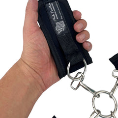 Glow&Vibe Bondage Lure negro, esposas de velcro para manos y pies con anillas metálicas y hebilla central.