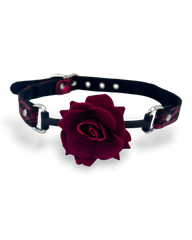 Glow&Vibe Rose Gag mordaza de silicona rosa oscuro con correa ajustable de tela negra y detalles rojos.