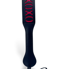 Paleta de azotes XOXO de cuero sintético negro con detalles rojos, de Glow&Vibe. Ideal para juegos de rol.
