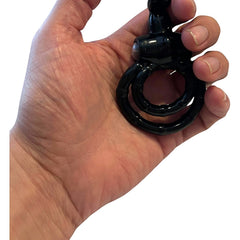 Anillo vibrador Passion Rabbit de color negro sostenido en la mano, accesorio de placer de la marca Glow&Vibe.