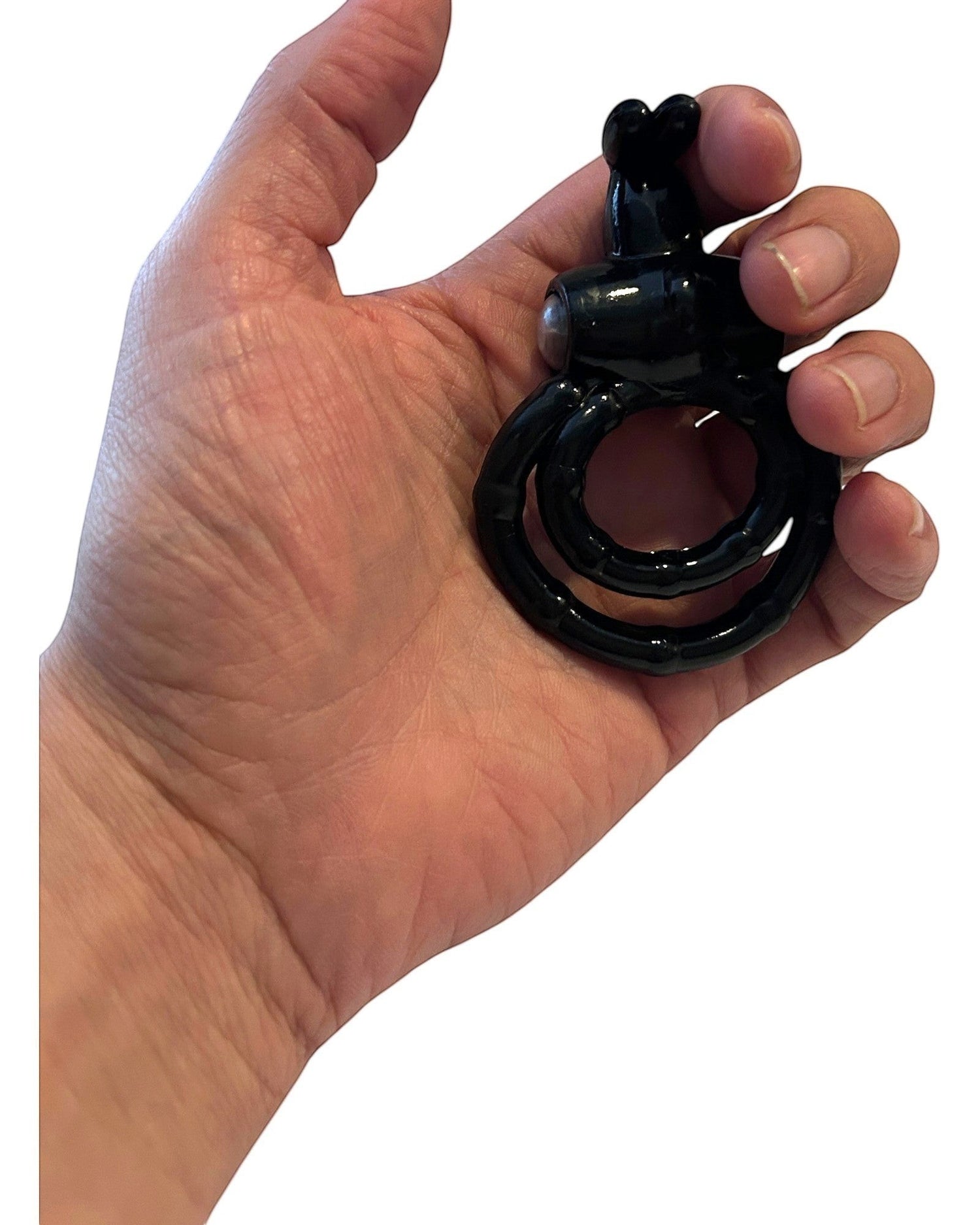 Anillo vibrador Passion Rabbit de color negro sostenido en la mano, accesorio de placer de la marca Glow&Vibe.